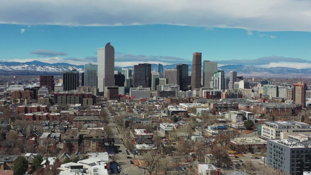 Slow rise revealing downtown denver with mountain backdrop SBI