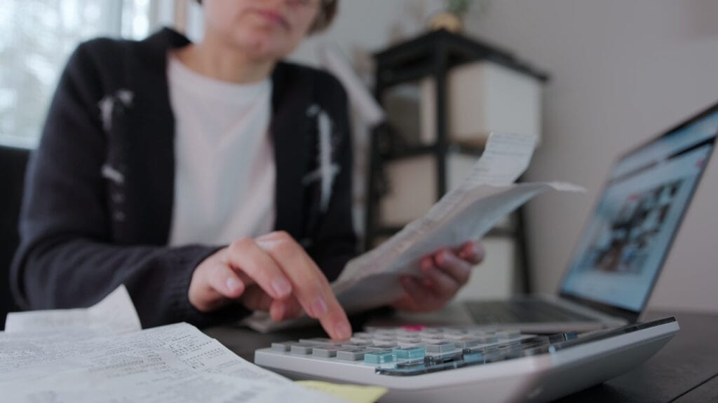 Woman checking bills taxes bank account balance and calculating expenses in the living SBI